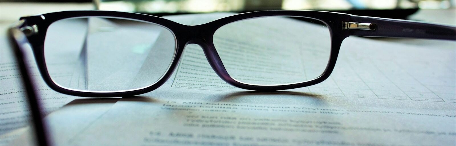 black-framed eyeglasses on white printing paper